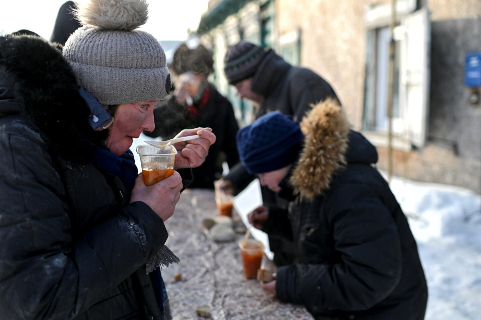 También hay voluntarios que se encargan de ayudarles. En la imagen, una mujer sin hogar toma comida caliente en un puesto colocado junto a un centro de reciclaje al que acuden habitualmente los sintecho a llevar los artículos que recogen. (Foto: Alexey Malgavko / Reuters).