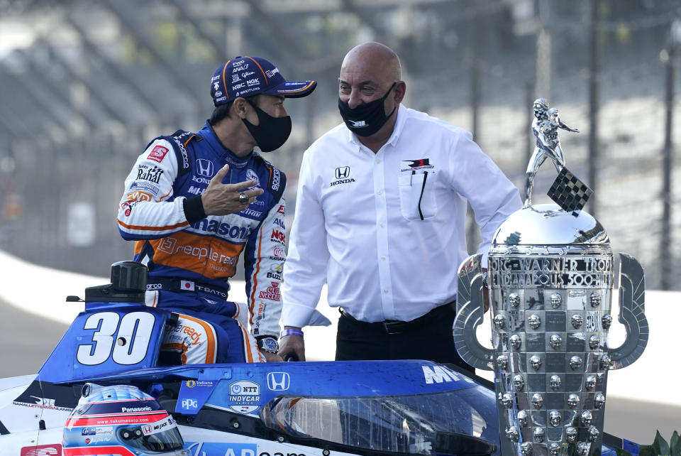 Takuma Sato, left, of Japan, winner of the 2020 Indianapolis 500 auto race, talks with Bobby Rahal during the traditional winners photo session at the Indianapolis Motor Speedway, Monday, Aug. 24, 2020, in Indianapolis. (AP Photo/Darron Cummings)
