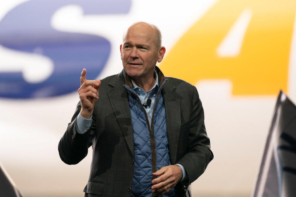 Boeing CEO Dave Calhoun stands in front of an Atlas Air Boeing 747 while speaking.