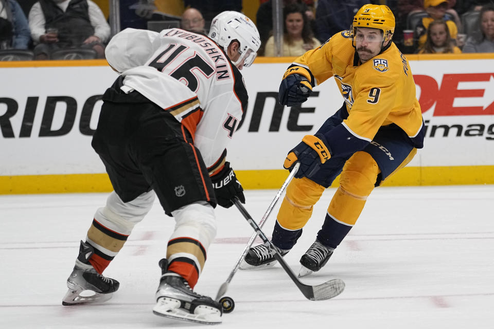 Nashville Predators left wing Filip Forsberg (9) tries to get the puck past Anaheim Ducks defenseman Ilya Lyubushkin, left, during the second period of an NHL hockey game Tuesday, Nov. 14, 2023, in Nashville, Tenn. (AP Photo/George Walker IV)