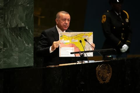 Recep Tayyip Erdogan, Turkey's president, holds up a map of his proposed "safe zone" while speaking during the UN General Assembly meeting in New York - Credit: Bloomberg