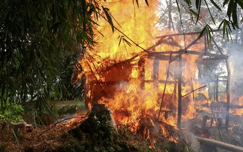 A house burns in Gawdu Tharya village near Maungdaw in Rakhine state in northern Burma  - Credit:  AFP