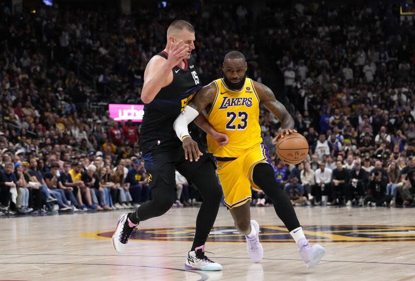 Los Angeles Lakers forward LeBron James (23) passes Denver Nuggets center Nikola Jokic, left, during the second half of Game 2 of a first-round NBA basketball playoff series on Monday, April 22, 2024, in Denver.  (AP Photo/Jack Dempsey)