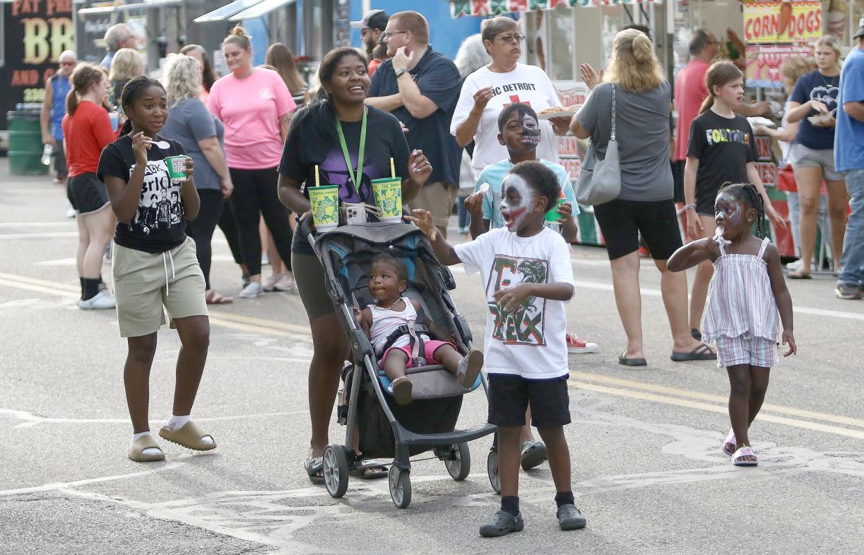 Members of the Harris family from Alliance walk down East Main Street on Thursday, Aug. 4, 2022, during the Carnation  Festival Food Fest.