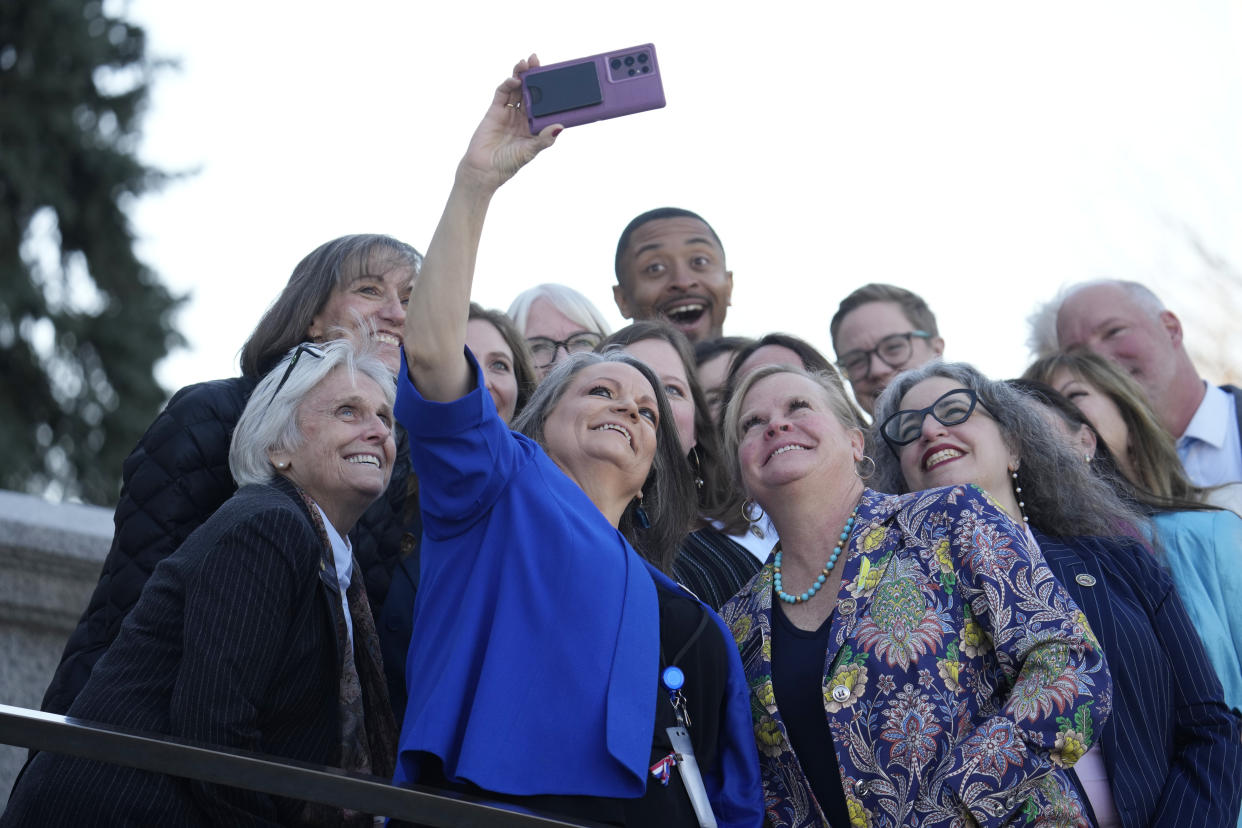 Colorado State rep. Sheila Lieder, front center, is joined by State Senator Joann Ginal, front left, and Rep. Meg Froelich, front right, and other lawmakers for a photograph before greeting first lady Jill Biden during a stop to attend a roundtable discussion on the federal workforce training program to help community college students earn certificates for entry-level jobs Monday, April 3, 2023, outside the State Capitol in Denver. Both Republican and Democratic state lawmakers were on hand for the first lady's visit, the first of four stops across the country to promote the Biden Administration's effort to invest in America. (AP Photo/David Zalubowski)