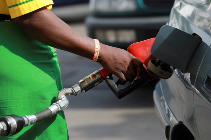 FILE PHOTO: A gas station attendant pumps fuel into a car at the NNPC Mega petrol station in Abuja