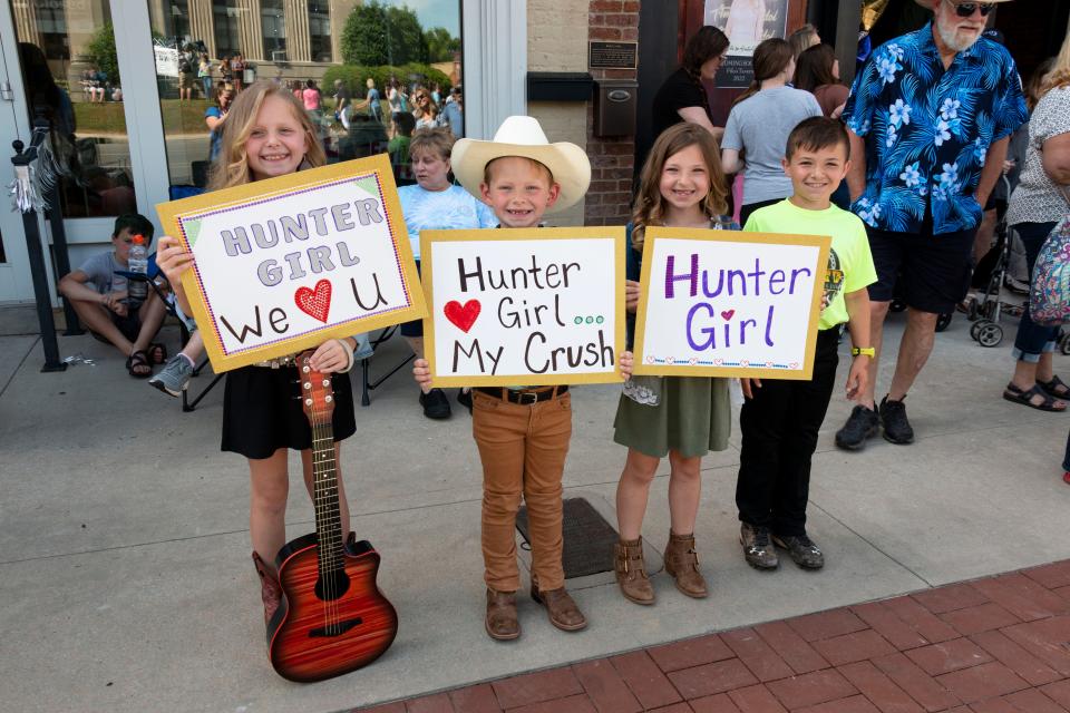 Harper and Hank Cundiff and Pailen and Preston Holt hold up their signs with big smiles to show their excitement for HunterGirl coming home on Tuesday, May, 17, 2022, during the HunterGirl Homecoming held in Winchester.