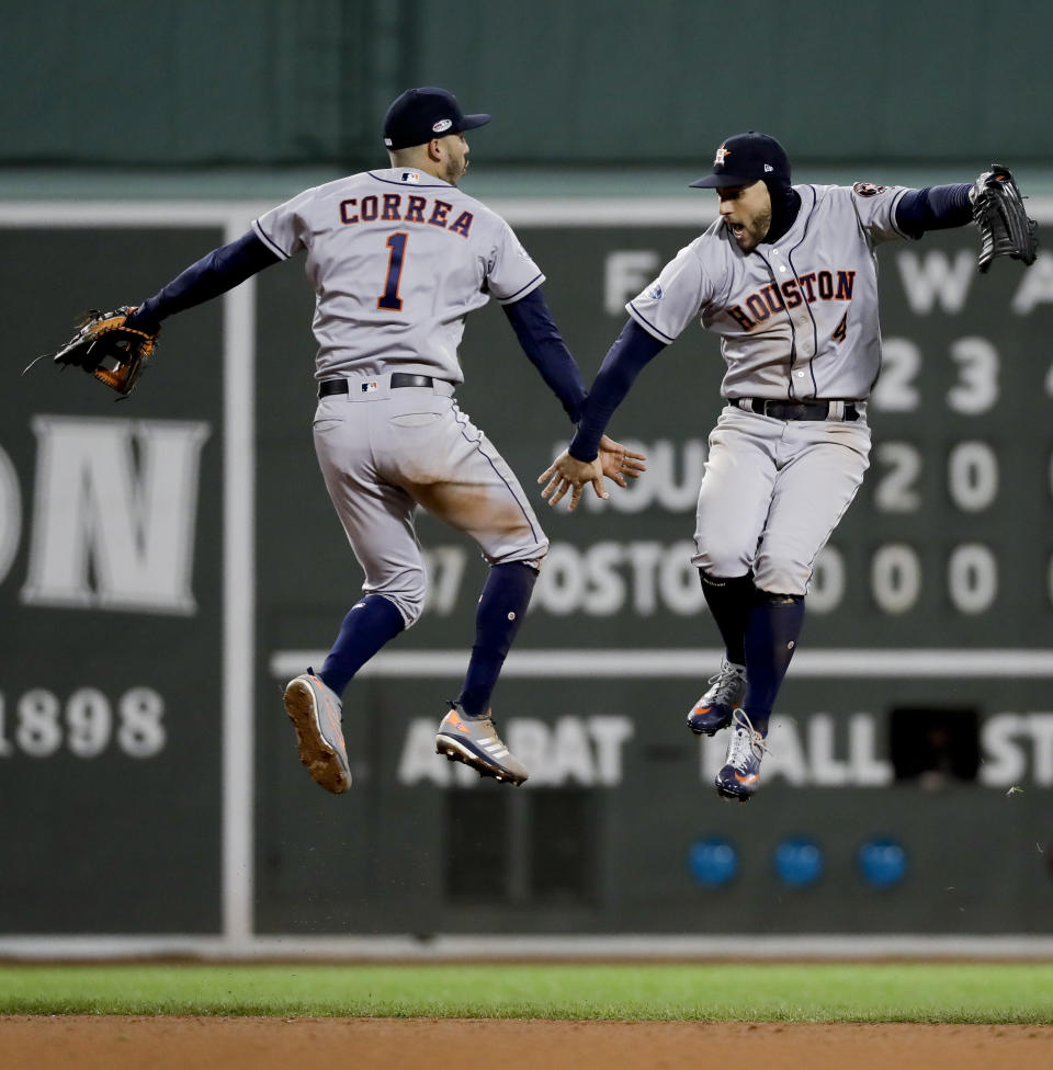 Houston Astros center fielder George Springer, right, and shortstop Carlos Correa celebrate their win against the Boston Red Sox in Game 1 of a baseball American League Championship Series on Saturday, Oct. 13, 2018, in Boston. The Astros won 7-2. (AP Photo/David J. Phillip)