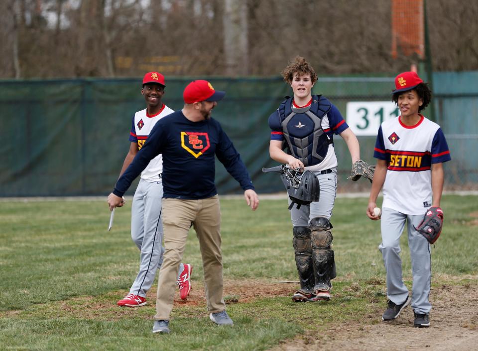 Seton freshman Kenny Gihozo (left), sophomore Nolan Burkhardt (center) and senior Tristian Washington (right) laugh with an assistant coach before a game against Randolph Southern March 30, 2022.