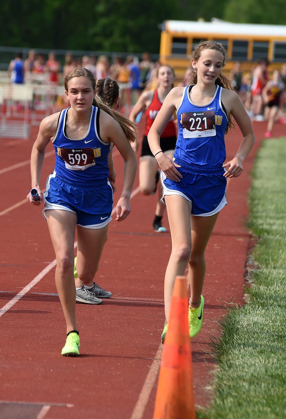 Kim Miller of Jefferson takes the baton from Riley Peer in the 3,200 relay as they won the Huron League Championship with a time of 10:14.22 Tuesday.