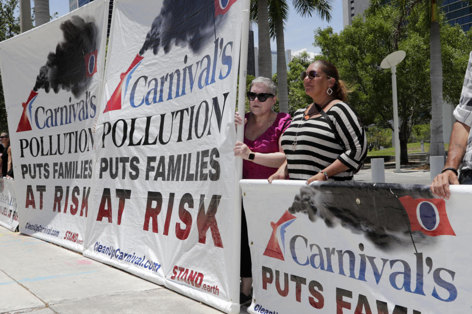 FILE - In this June 3, 2019 file photo, protesters with Stand.earth hold a banner in opposition to Carnival Corp. outside of federal court, in Miami. Top Carnival Corp. executives are due back in court to explain what the world's largest cruise line is doing to reduce ocean pollution. A hearing is set Wednesday, Oct. 2, 2019, in Miami federal court for an update on what steps Carnival is taking. (AP Photo/Lynne Sladky, File)