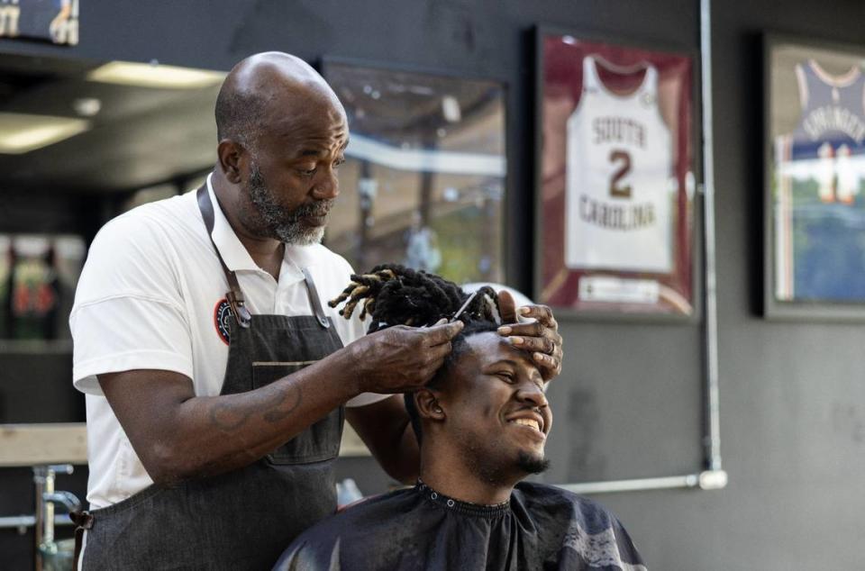 Brian Mack, left, cuts his son’s hair, B.J., at House of Hoops Barbershop in Charlotte, N.C., on Monday, July 1, 2024.