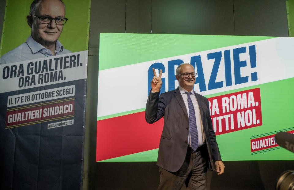 Center-left mayoral candidate Roberto Gualtieri flashes a v-sign at his party's headquarters in Rome, Monday, Oct. 18, 2021. Romans are waiting to learn who will be their next mayor, following runoff elections that ended Monday in the Italian capital. The top vote-getters in the first round of balloting two weeks earlier, Enrico Michetti, a novice politician backed by a far-right leader, and Roberto Gualtieri, a Democrat and former finance minister, competed in the runoff Sunday and Monday. Italian writing in background read: 'Thank you! Now Gualtieri, now Rome. (AP Photo/Gregorio Borgia)
