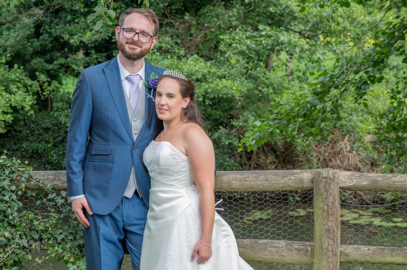 Michael on the left and Amy on the right, both wearing their wedding outfits