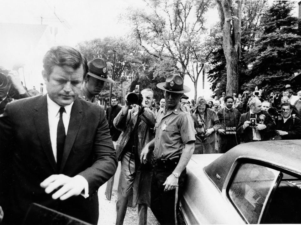 A photographer points a camera toward Sen. Edward M. Kennedy as he leaves a courthouse in 1969