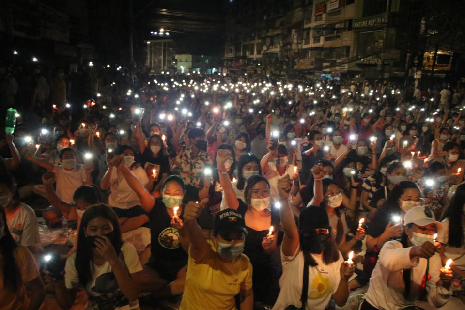 People raise their hands with clenched fists while others hold up mobile phones with LED lights on, during a candlelight night rally in Yangon, Myanmar Saturday, March 13, 2021. Security forces in Myanmar on Saturday again met protests against last month's military takeover with lethal force, killing at least four people by shooting live ammunition at demonstrators. (AP Photo)