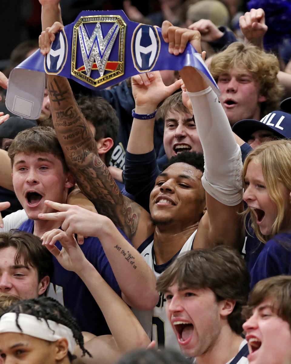 Hoban guard Jonas Nichols, center, holds up a WWE title as he celebrates the Knights' 49-36 victory over Toledo St. John's Jesuit in a Division I state semifinal basketball game at UD Arena, Saturday, March 18, 2023, in Dayton, Ohio.