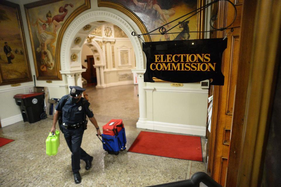 A Brockton police officer returns election results at Brockton City Hall on Tuesday, Sept. 14, 2021.