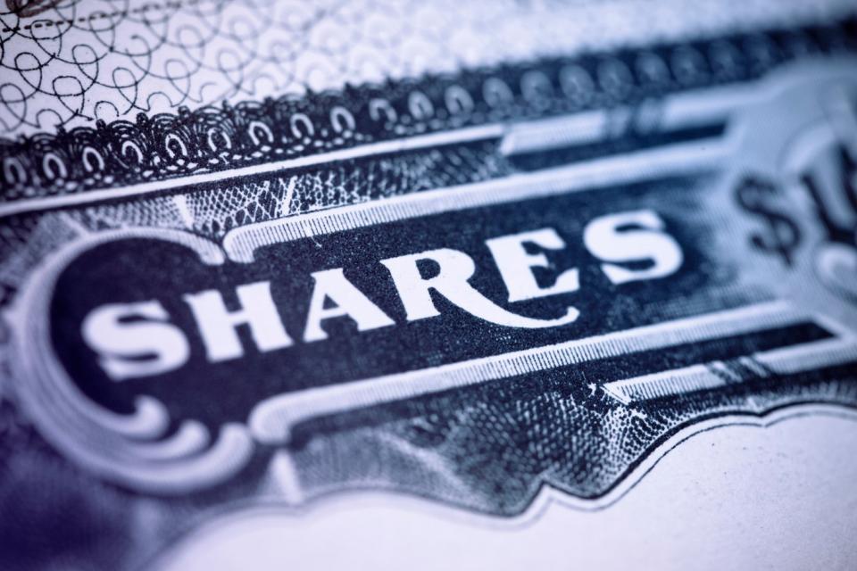 A close-up of the word shares on a paper stock certificate of a publicly traded company.