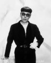 <p>American costume designer Edith Head wearing an all-black belted outfit with white gloves and a string of classic pearls.</p>