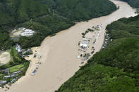 This aerial view shows the Kuma River flooded with heavy rain in Yatsushiro, Kumamoto prefecture, southwestern Japan, Saturday, July 4, 2020. The Japan Meteorological Agency raised the heavy rain warnings in many parts of the prefectures to the highest level shortly before 5 a.m. It was the first time for the agency to do so in the two prefectures, Kumamoto and Kagoshima. (Kyodo News via AP)