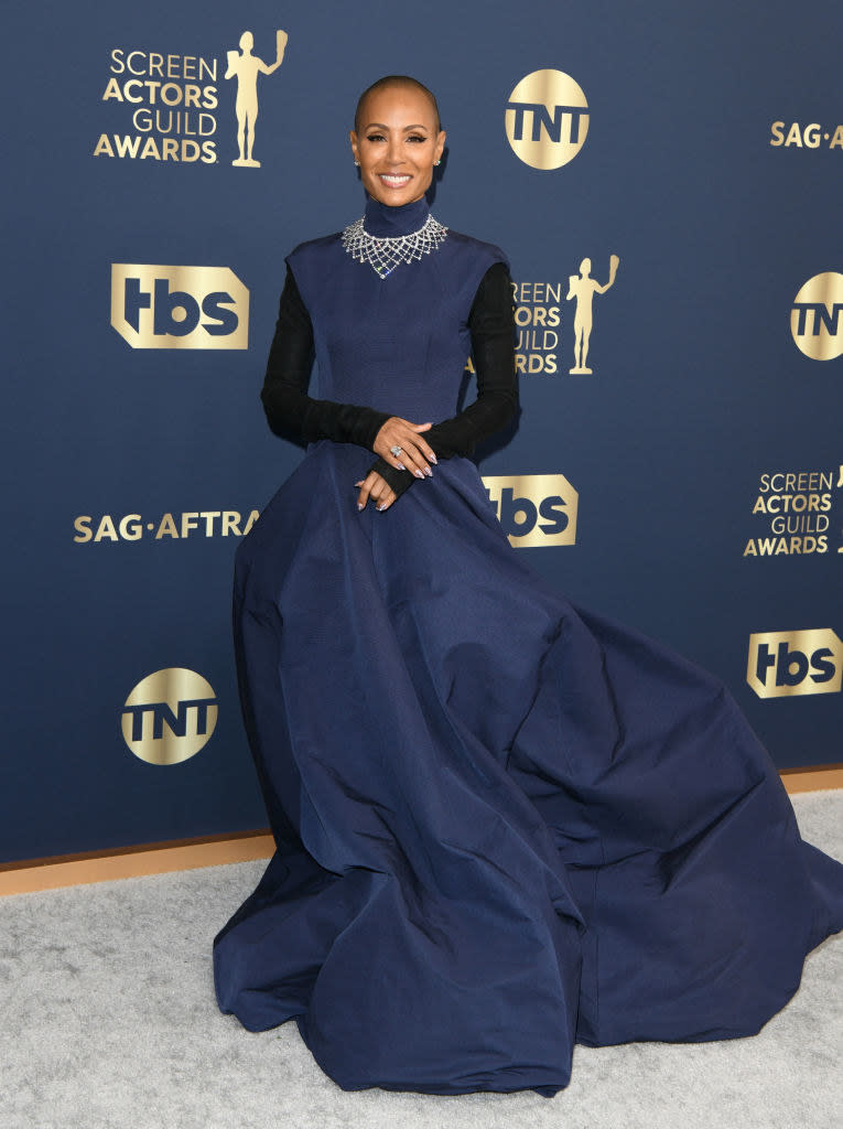 a turtleneck ballgown with cap sleeves and a bubbly skirt worn over a long-sleeves shirt and adorned with a large choker