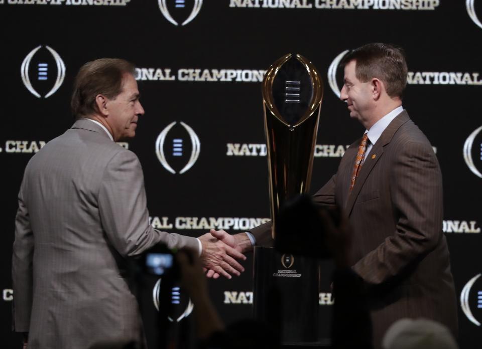 Alabama head coach Nick Saban and Clemson head coach Dabo Swinney pose with the trophy at a news conference for the NCAA college football playoff championship game Sunday, Jan. 6, 2019, in Santa Clara, Calif. (AP Photo/Chris Carlson)