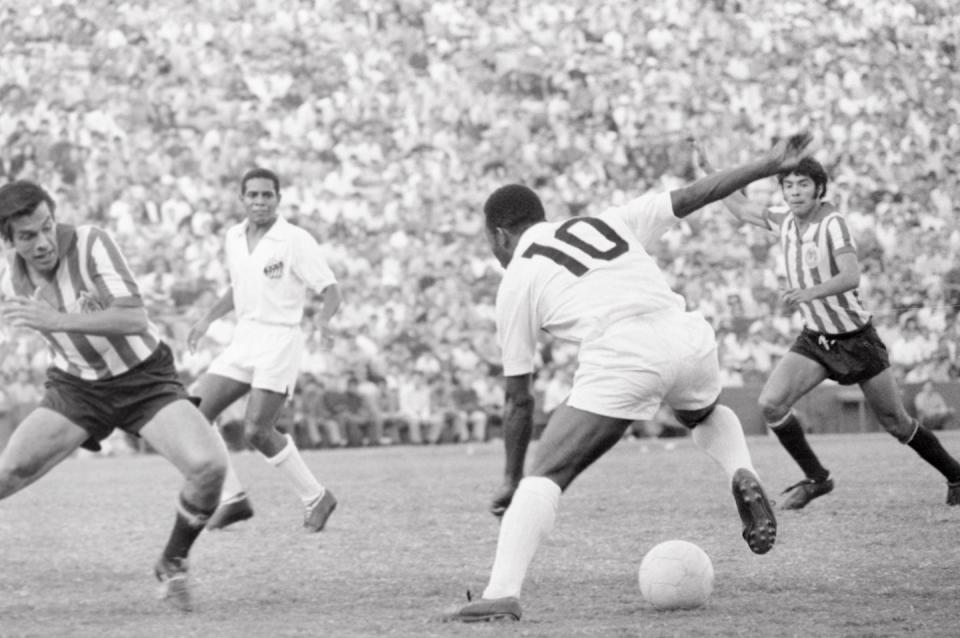 original caption picking up the ball los angeles, california brazilian star soccer player pele 10 rushed in to pick up the ball before guadalajara, mexico, player r estrada left can get to it, during the first half of the santos guadalajara game here sept 20th the game, part of the international soccer football championships, was won by the brazilian team, 2 1