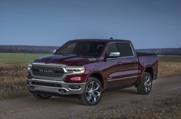 A dark red 2019 Ram 1500, a full-size pickup truck, parked next to a farm field.