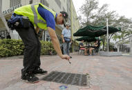 <p>Miami-Dade mosquito control contractor Alejandro Espinosa pours chemicals into a storm sewer on a sidewalk, Friday, Sept. 2, 2016, in Miami Beach, Fla. (AP Photo/Alan Diaz)</p>