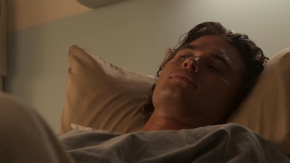 Chase Stokes as John B in a hospital bed after falling out of the Hawks Nest