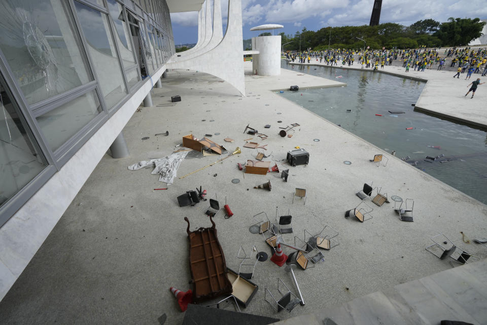 Furniture that was thrown out of Planalto Palace by protesters, supporters of Brazil's former President Jair Bolsonaro, lay on the ground after the protesters stormed the official workplace of the president in Brasilia, Brazil, Sunday, Jan. 8, 2023. (AP Photo/Eraldo Peres)