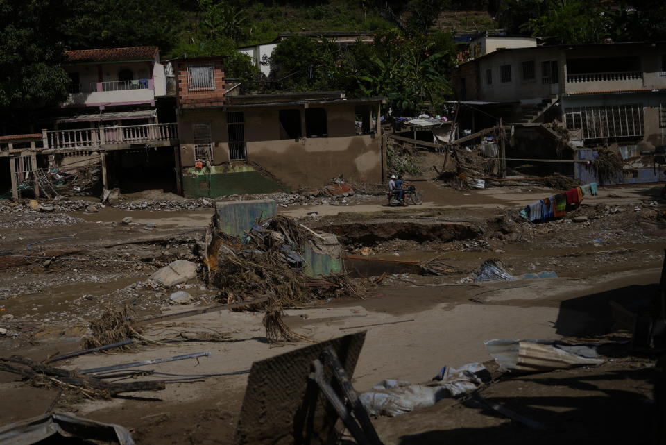 Residents survey the damage after deadly flooding in Las Tejerias, Venezuela, Monday, Oct. 10, 2022. A fatal landslide fueled by flooding and days of torrential rain swept through this town in central Venezuela. (AP Photo/Matias Delacroix)