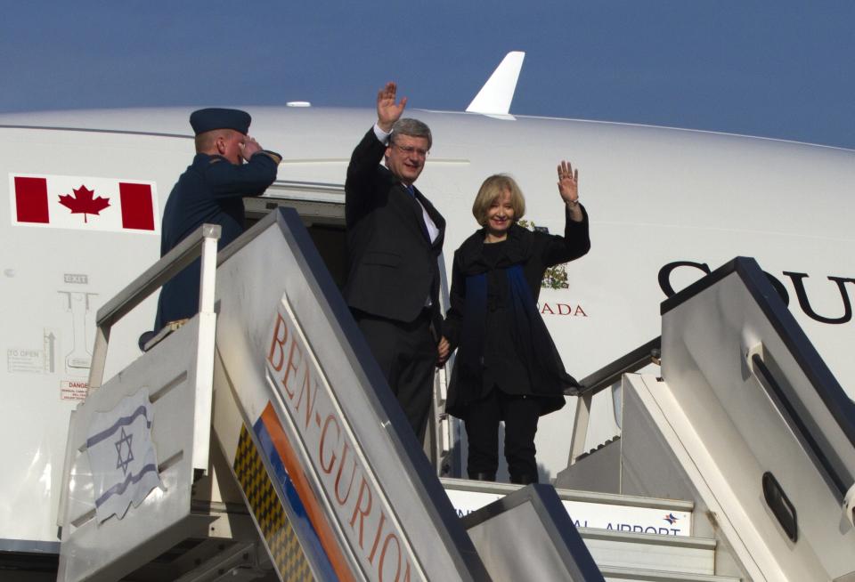 Canada's Prime Minister Harper and his wife wave as they disembark from their plane after landing at airport near Tel Aviv