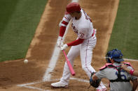 Los Angeles Angels designated hitter Shohei Ohtani, left, hits an infield single with Los Angeles Dodgers catcher Will Smith watching during the first inning of a baseball game in Anaheim, Calif., Sunday, May 9, 2021. (AP Photo/Alex Gallardo)