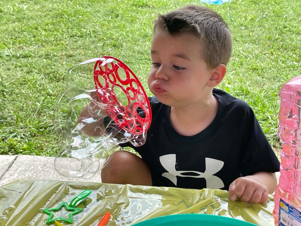 Holden Rogers is taken with the bubble wand and blows thousands of little bubbles at the annual Hardin Valley Elementary School Popsicle Party held at the school Sunday, Aug. 14, 2022.