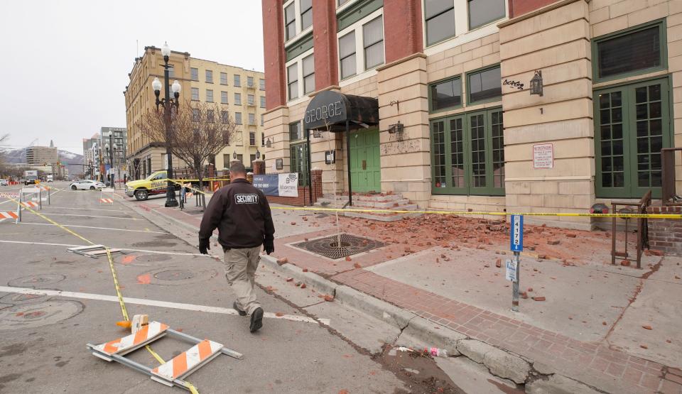 A security guard scans damage caused by an earthquake that rocked downtown Salt Lake City on March 18, 2020, less than a day after the city was put on coronavirus lockdown.