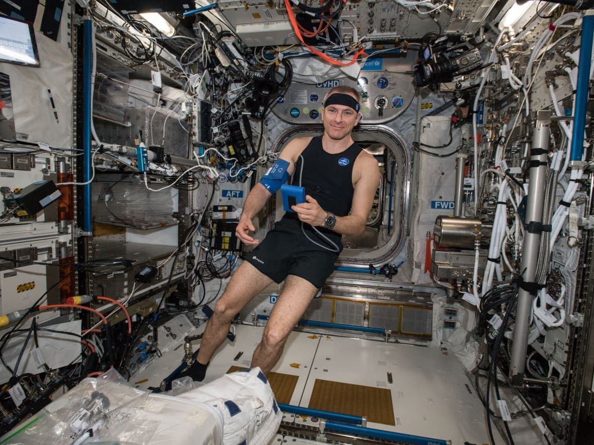 In a photo from 2019, taken aboard the International Space Station, astronaut David Saint-Jacques tries out the Bio-Monitor for the first time in space. The Canadian technology is a smart shirt system designed to measure and record vital signs. (Canadian Space Agency/NASA - image credit)