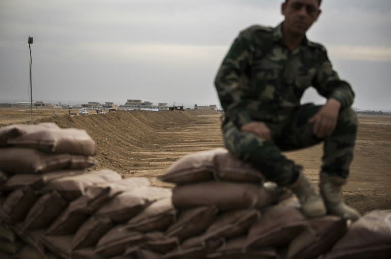 A Peshmerga fighter sits on the berm