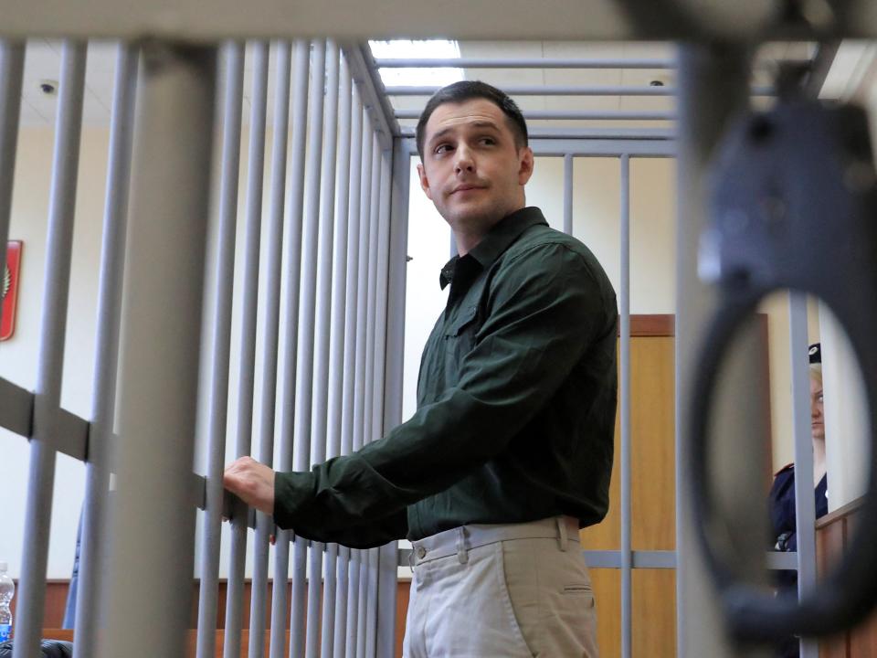 U.S. ex-Marine Trevor Reed, who was detained in 2019 and accused of assaulting police officers, stands inside a defendants' cage during a court hearing in Moscow, Russia March 11, 2020.