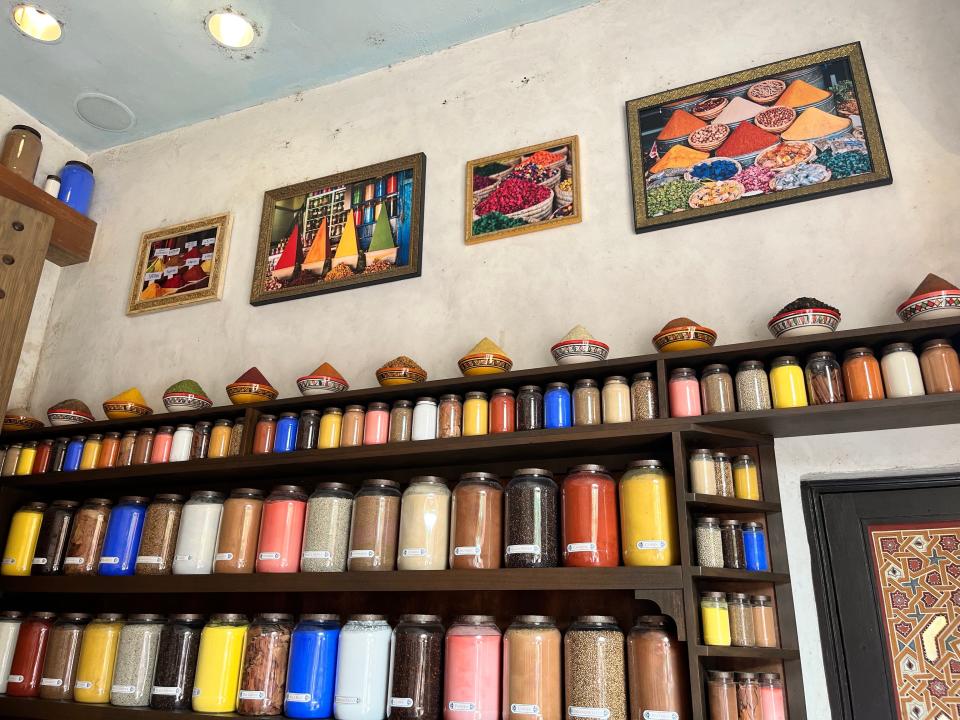 Rows of spices and artwork on the walls of Spice Road Table.