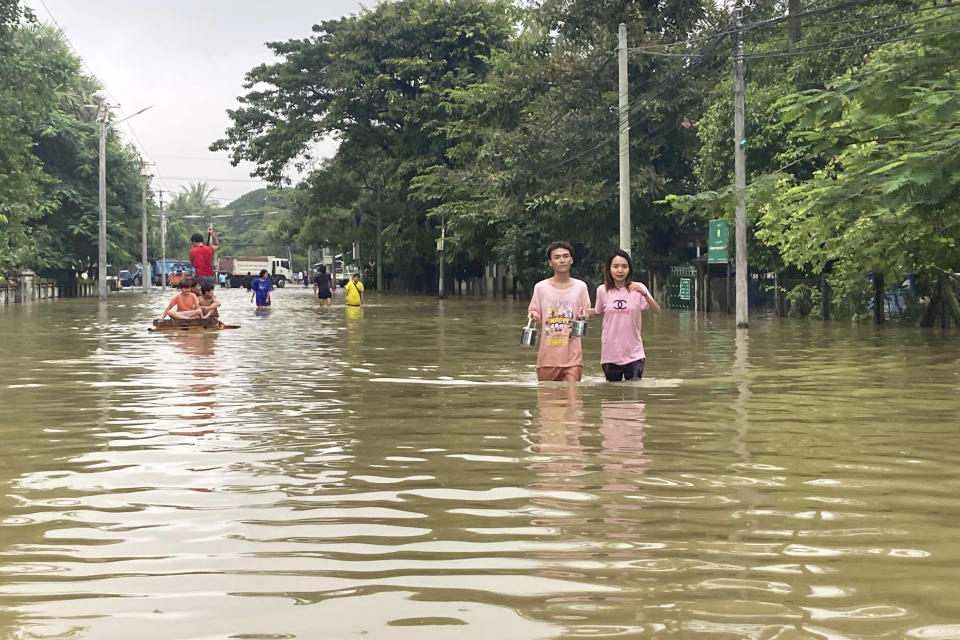 Local residents wade through a flooded road in Bago, about 80 kilometers (50 miles) northeast of Yangon, Myanmar, Monday, Oct. 9, 2023. Flooding triggered by heavy monsoon rains in Myanmar’s southern areas has displaced more than 10,000 people and disrupted traffic on the rail lines that connect the country’s biggest cities, officials and state-run media said Monday. (AP Photo/Thein Zaw)