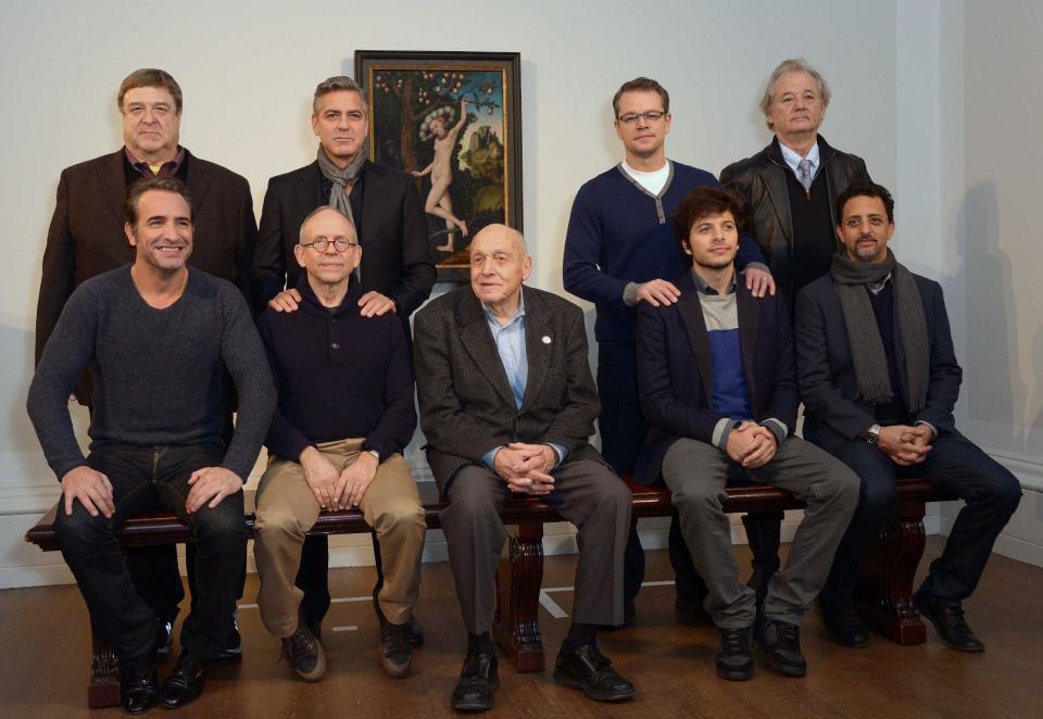 Cast members of the film The Monuments Men pose during a photocall in front of 'Cupid Complaining To Venus', by Lucas Cranach the Elder, believed to be from Adolf Hitler's private collection, at the National Gallery, in London, Tuesday, Feb. 11, 2014. From left to right seated, French actor Jean Dujardin, US actor Bob Balaban, real life 'monument man' Harry Ettlinger , British actor Dimitri Leonidas and US actor Grant Heslov. In background from left to right, US actors, John Goodman, George Clooney, Matt Damon and Bill Murray. (Photo by Jon Furniss/Invision/AP)