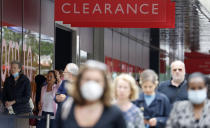 People, some wearing masks queue outside a John Lewis store, in London, Thursday, July 16, 2020. Unemployment across the U.K. has held steady during the coronavirus lockdown as a result of a government salary support scheme, but there are clear signals emerging that job losses will skyrocket over coming months. The Office for National Statistics said Thursday there were 649,000 fewer people, or 2.2%, on payroll in June when compared with March when the lockdown restrictions were imposed. (AP Photo/Alastair Grant)