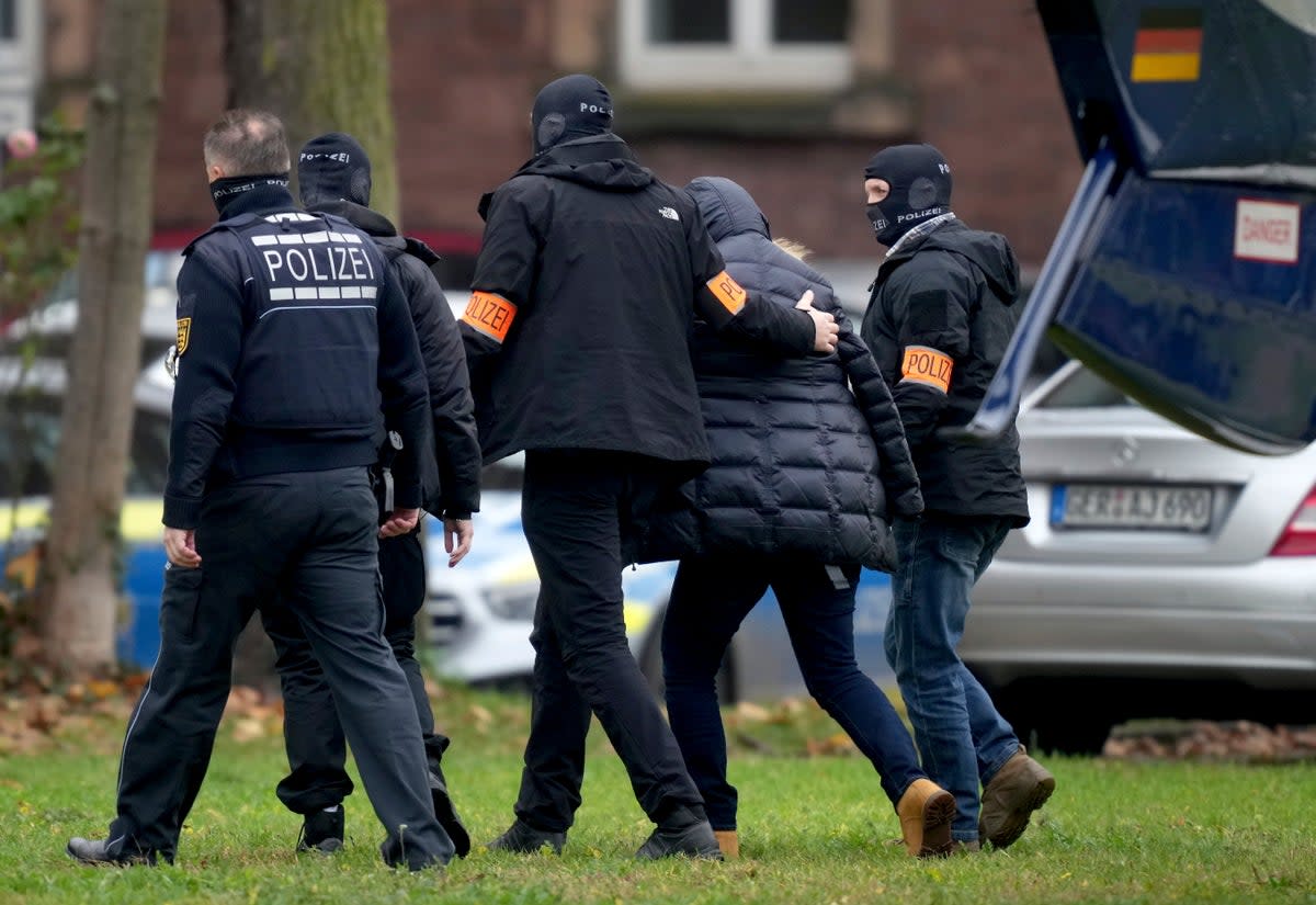 A suspect, second right, is escorted from a police helicopter by officers for questioning at the federal prosecutor’s office in Karlsruhe (AP)