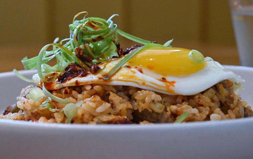 El desayuno con arroz frito de Yolked Kitchen incluye kimchi, paletilla de cerdo estofada, cebollas verdes, salsa de soya, chile crujiente y un huevo frito. Fotografiado el jueves 11 de julio de 2024 en Clovis.