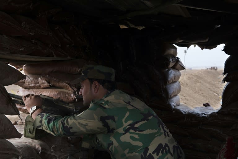 A Peshmerga soldier mans a fortified position along the berm