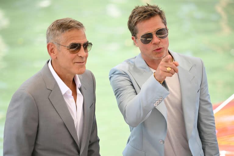 George Clooney y Brad Pitt posan para los fotógrafos que los esperan a su llegada al festival