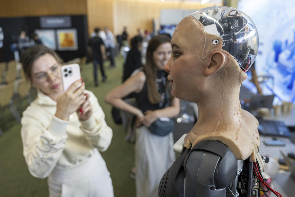 Una mujer fotografía a la robot humanoide Sophia durante una reunión internacional en Ginebra, Suiza, el miércoles 5 de julio de 2023. (Martial Trezzini/Keystone vía AP)