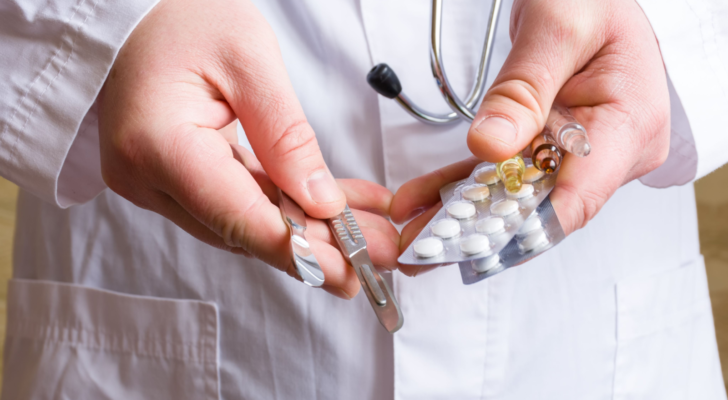 Concept photo choice or strategy for treating patient - surgical (operation) or therapeutic (with medications). Doctor holds surgical scalpels in one hand, in another - pills in blisters and ampoules. SONN Stock